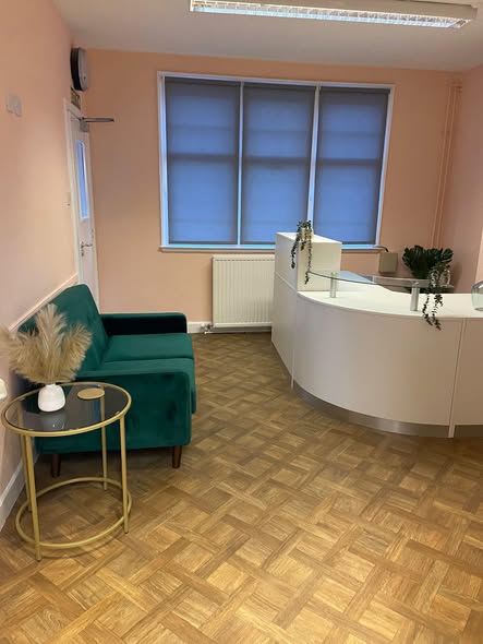 The Coach House reception with green chairs and a curved white desk